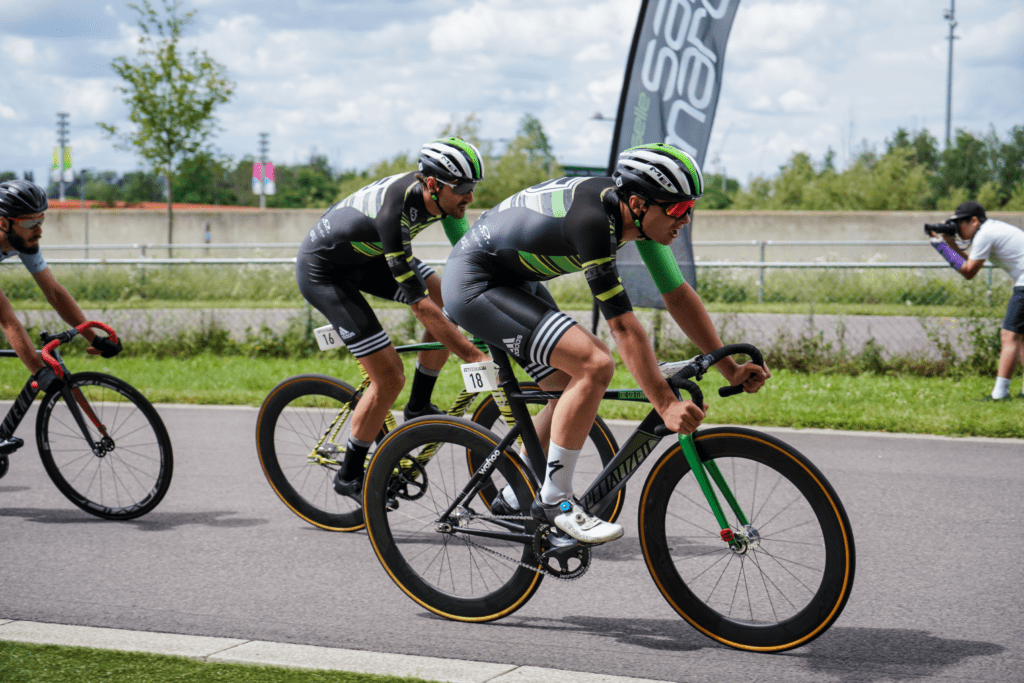 Ciclistas pedalando em pista asfaltada. Foto de Yomex Owo, Unsplash.