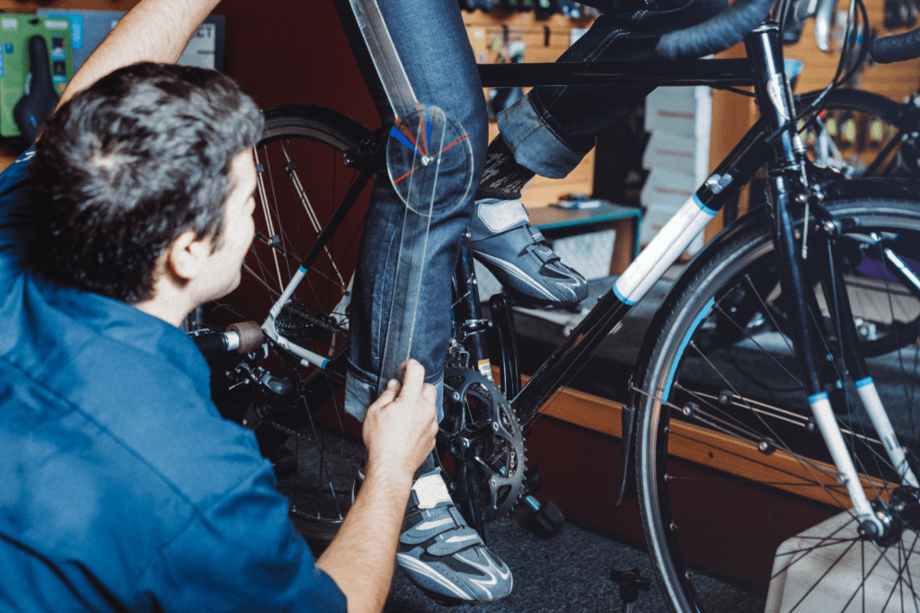 Foto: iStock. Profissional tirando medidas do corpo do ciclista.